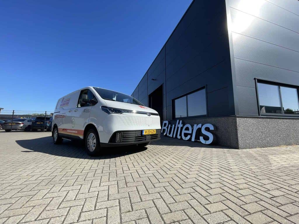 Klein witte bedrijfsauto voor de ambulance op parkeerplaats bij Bulters bedrijfspand.