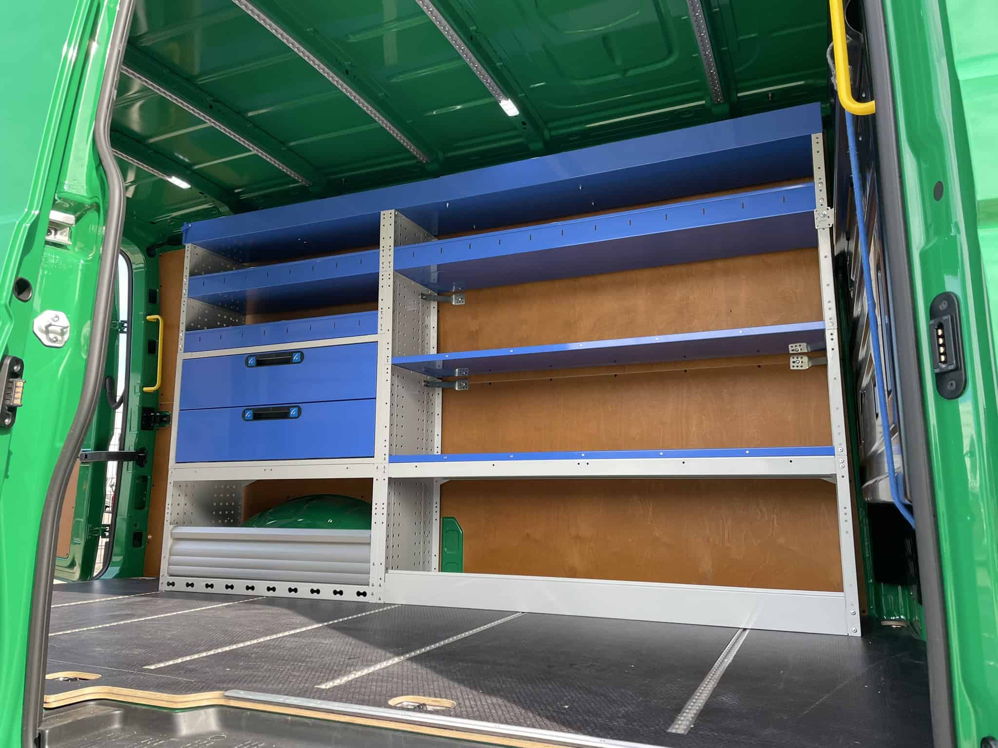 Gerestaureerde bedrijfswageninrichting met opbergkasten en legborden, perfect voor mobiel werken en opslagoptimalisatie.