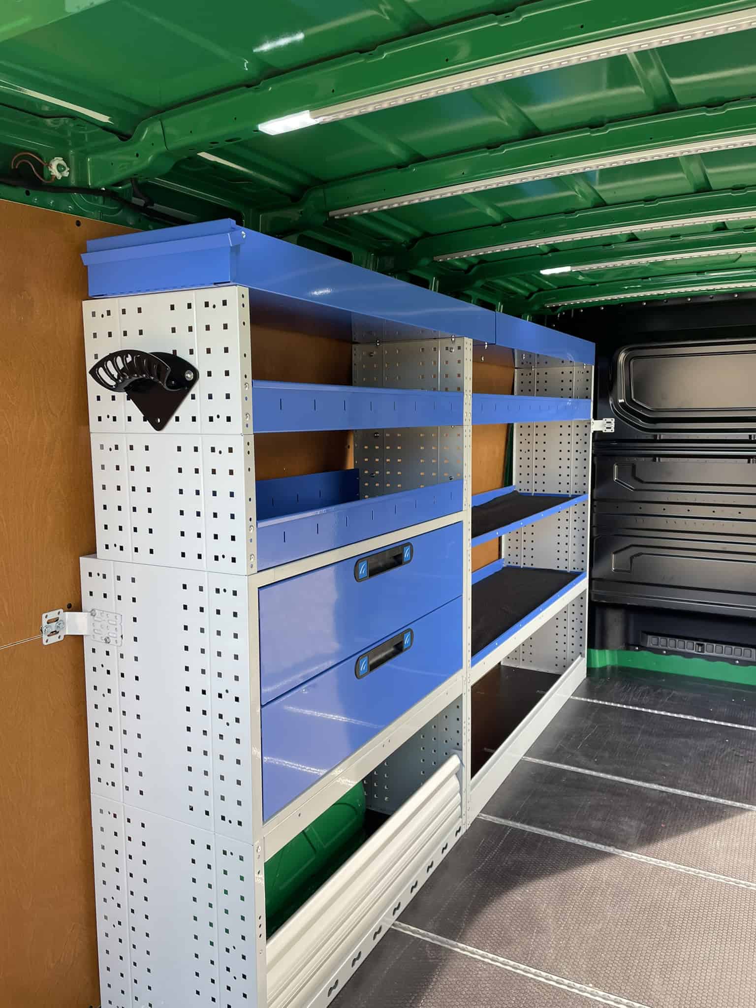 Robuuste bedrijfswagen inrichtingskast met accessoires, assortiment aan opbergmogelijkheden voor professioneel gebruik. Geïnstalleerd in een bedrijfswagen voor optimale organisatie en efficiëntie.