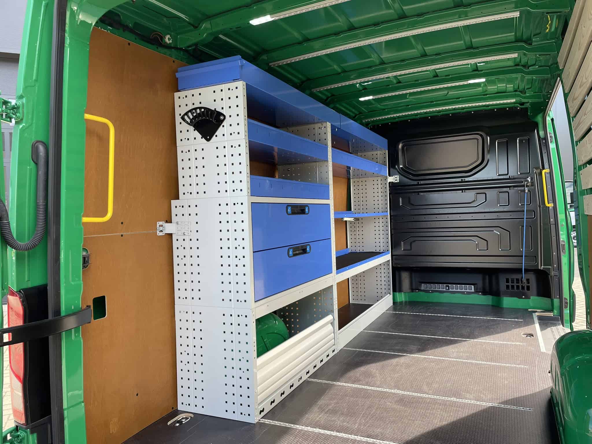 Georganiseerde bedrijfswageninrichting met draaiend werkbank en opbergkasten voor efficiënte werkplaats, perfect voor bedrijfswagens en bedrijfsvoertuigen.