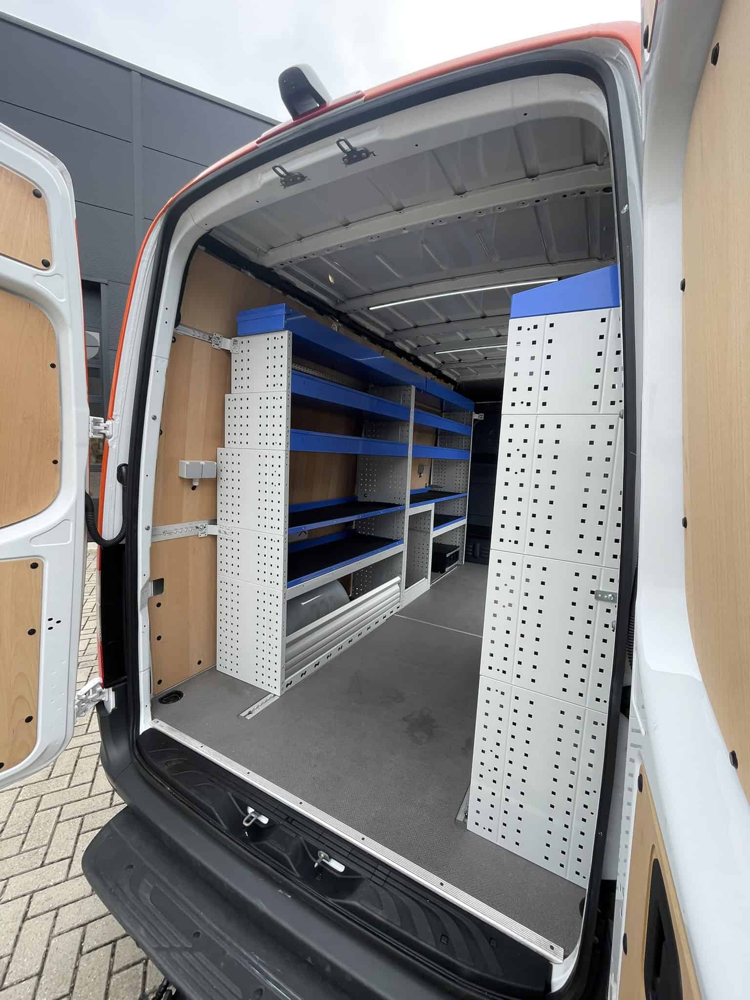 Gevel, bedrijfswagen interieur met georganiseerde opbergruimte, metalen rekken en houten panelen voor vakmanschap en transport.