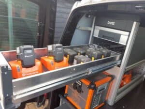 1. Alternatief tekst: Uitgebreide bedrijfswageninrichting met accu’s en opladers voor professionele werkzaamheden in een bedrijfsbus.