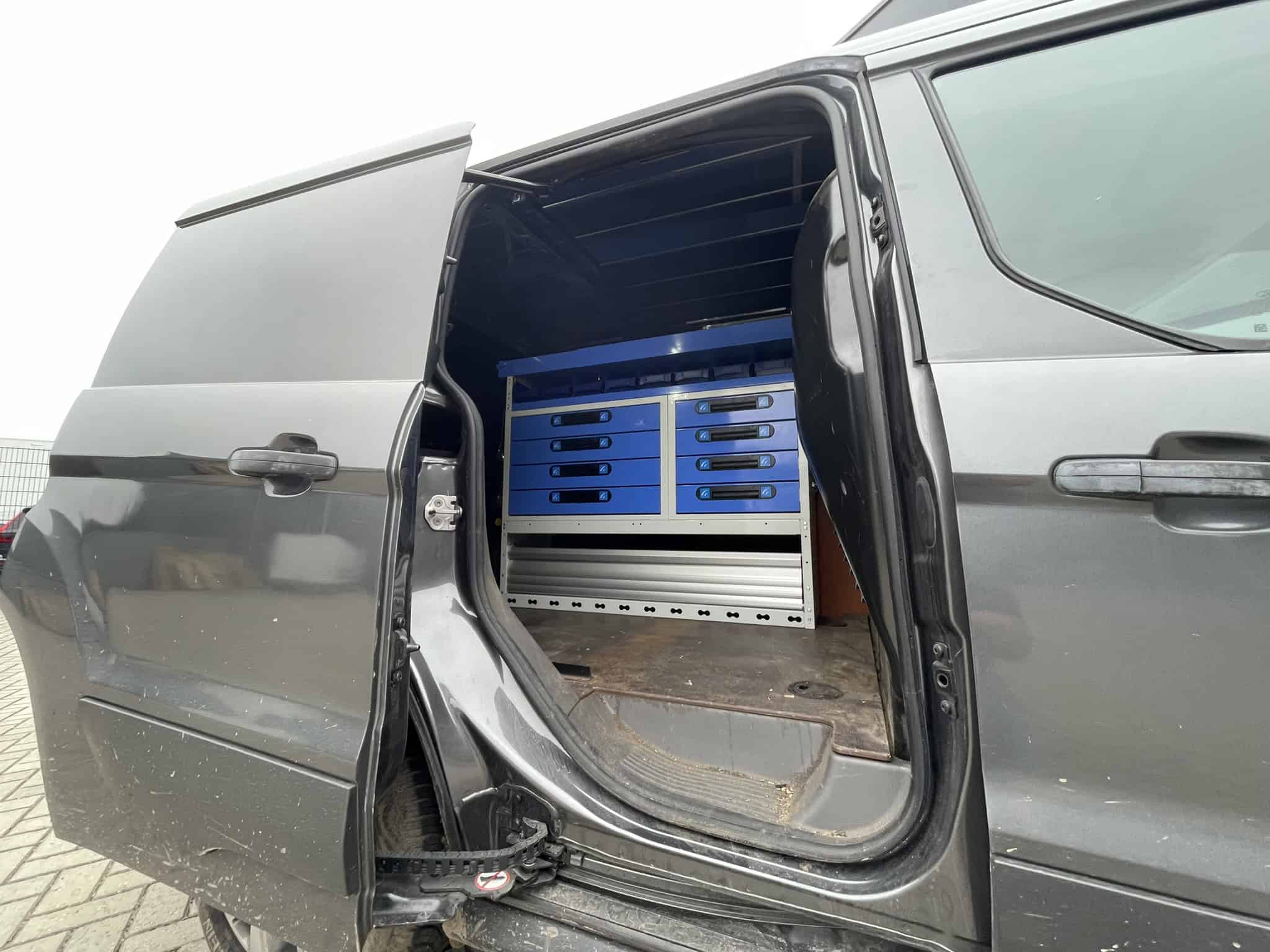 Werkplaatsinrichting voor bedrijfswagens met op maat gemaakte kasten en opbergoplossingen, ideaal voor professionele werkvoertuigen.