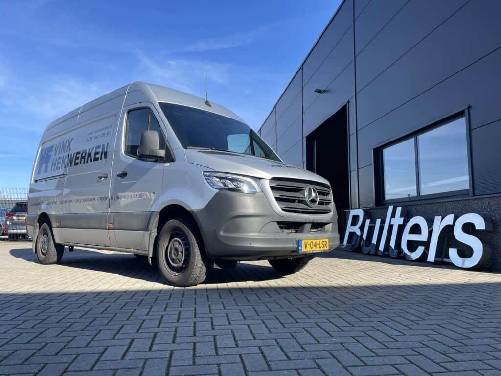 Bedrijfswagen met professionele inrichting voor bedrijfswagen, geparkeerd voor een modern bedrijfspand met logo. Ideaal voor transport en logistiek, met focus op functionaliteit en efficiëntie.