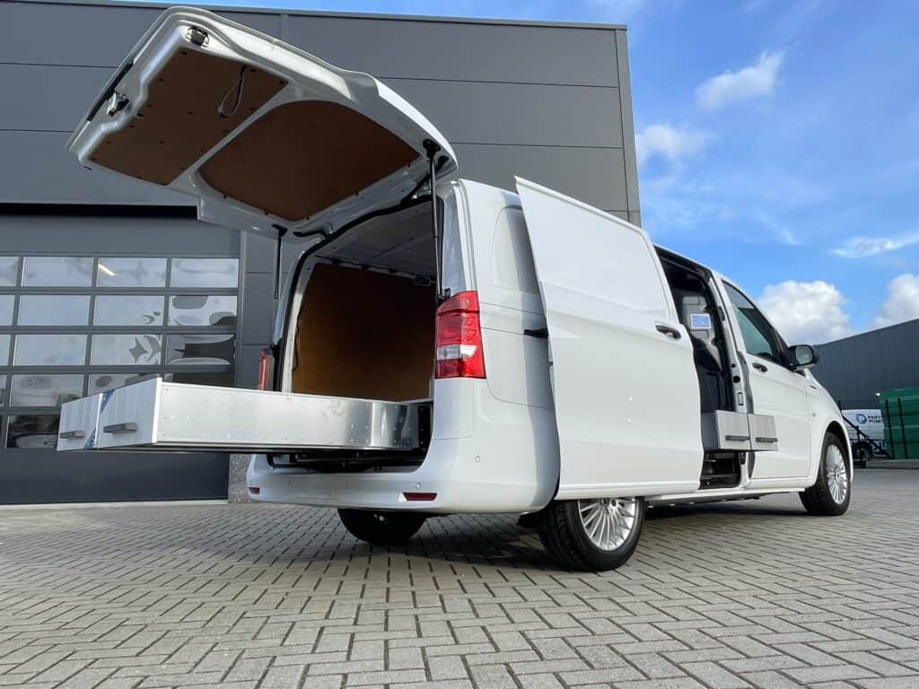 Bedrijfswagen met open achterdeur, toont dubbele bodem en zijwandinrichting voor efficiënte bedrijfswageninrichting.