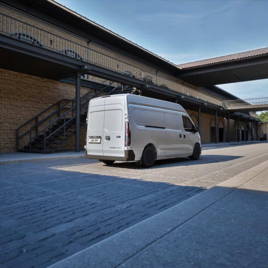 Bedrijfswagen met op maat gemaakte bedrijfsinrichting voor logistiek en transport, geparkeerd voor een industrieel gebouw.
