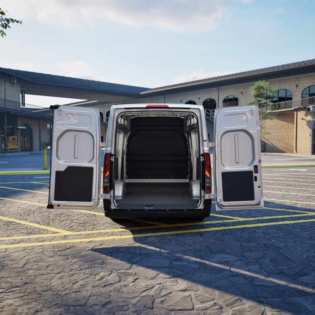 Bedrijfswagen met open achterdeuren, geschikt voor bedrijfsinrichting en transport, geparkeerd op een parkeerplaats in een commerciële omgeving.