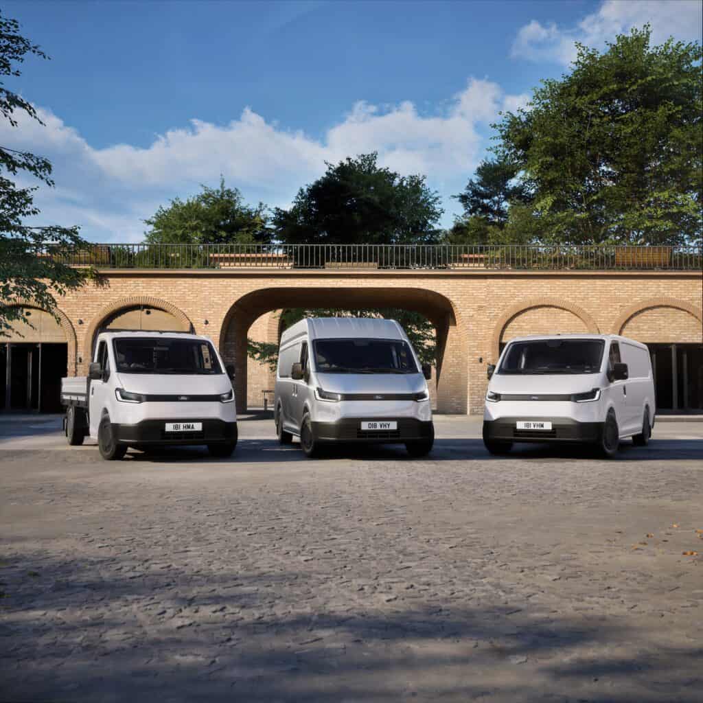 Drie bedrijfswagens geparkeerd voor een historische brug, ideaal voor bedrijfswageninrichting en transportdiensten.
