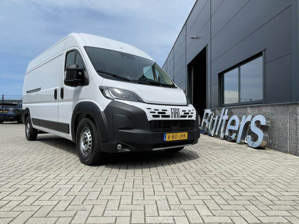 Moderne witte bedrijfswagen geparkeerd voor een bedrijfspand, geschikt voor zakelijke transport en bedrijfsinrichting.