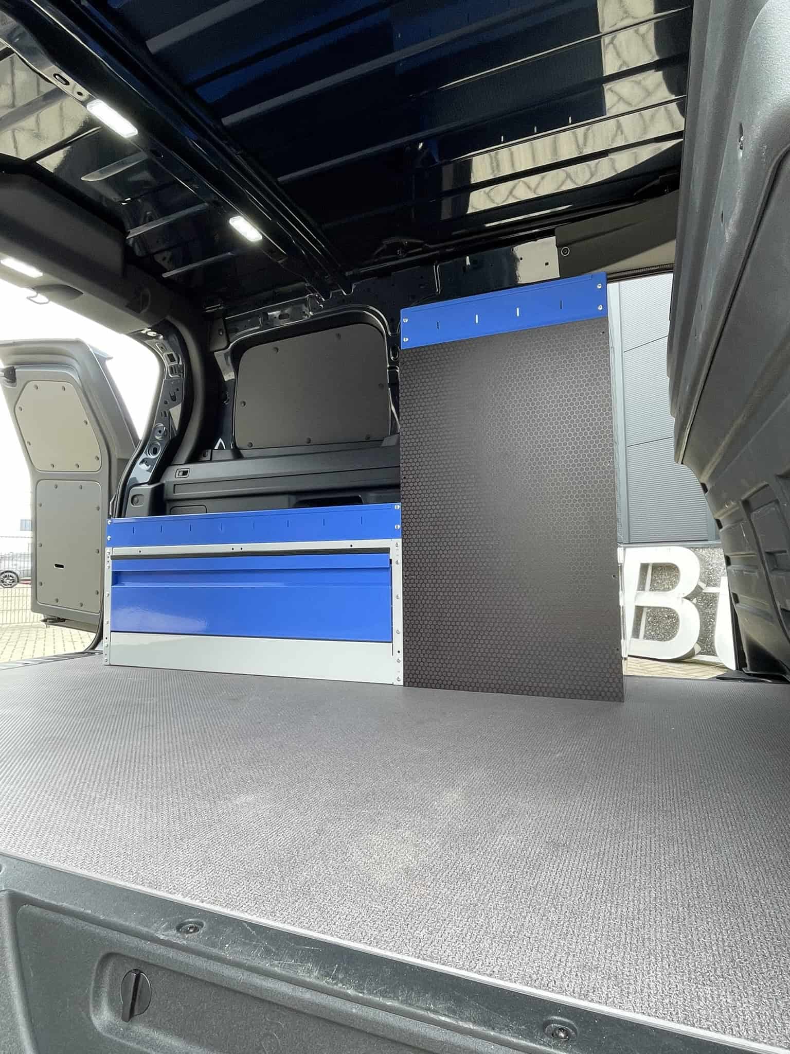 Interieur van een bedrijfswagen met opbergkasten en werkblad voor professionele inrichting.
