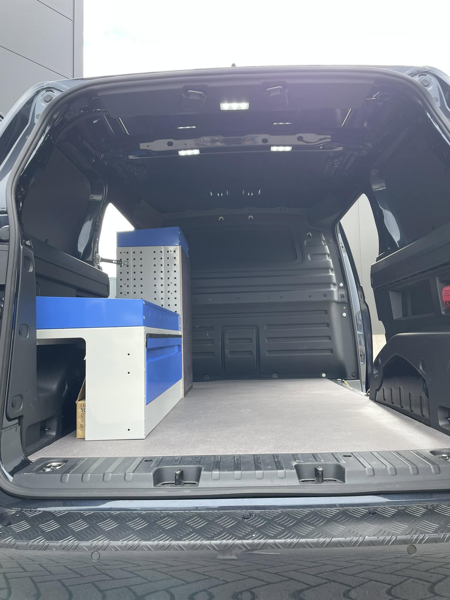 Binnenkant van een bedrijfswagen met opbergkast en werkruimte, ideaal voor bedrijfsdoeleinden.