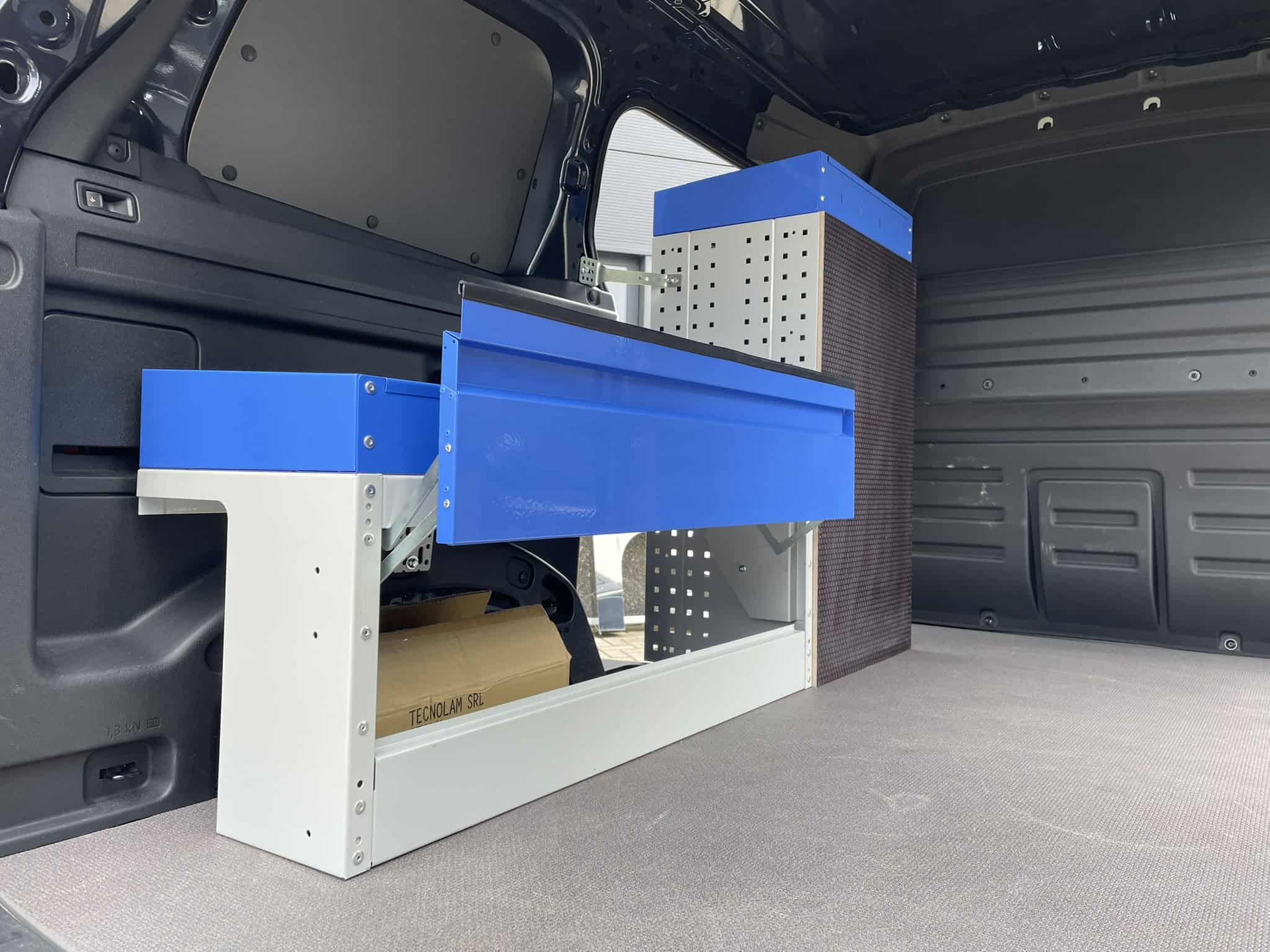 Geïntegreerde werkbank en opbergoplossingen in bedrijfswagen voor efficiënte werkplek.