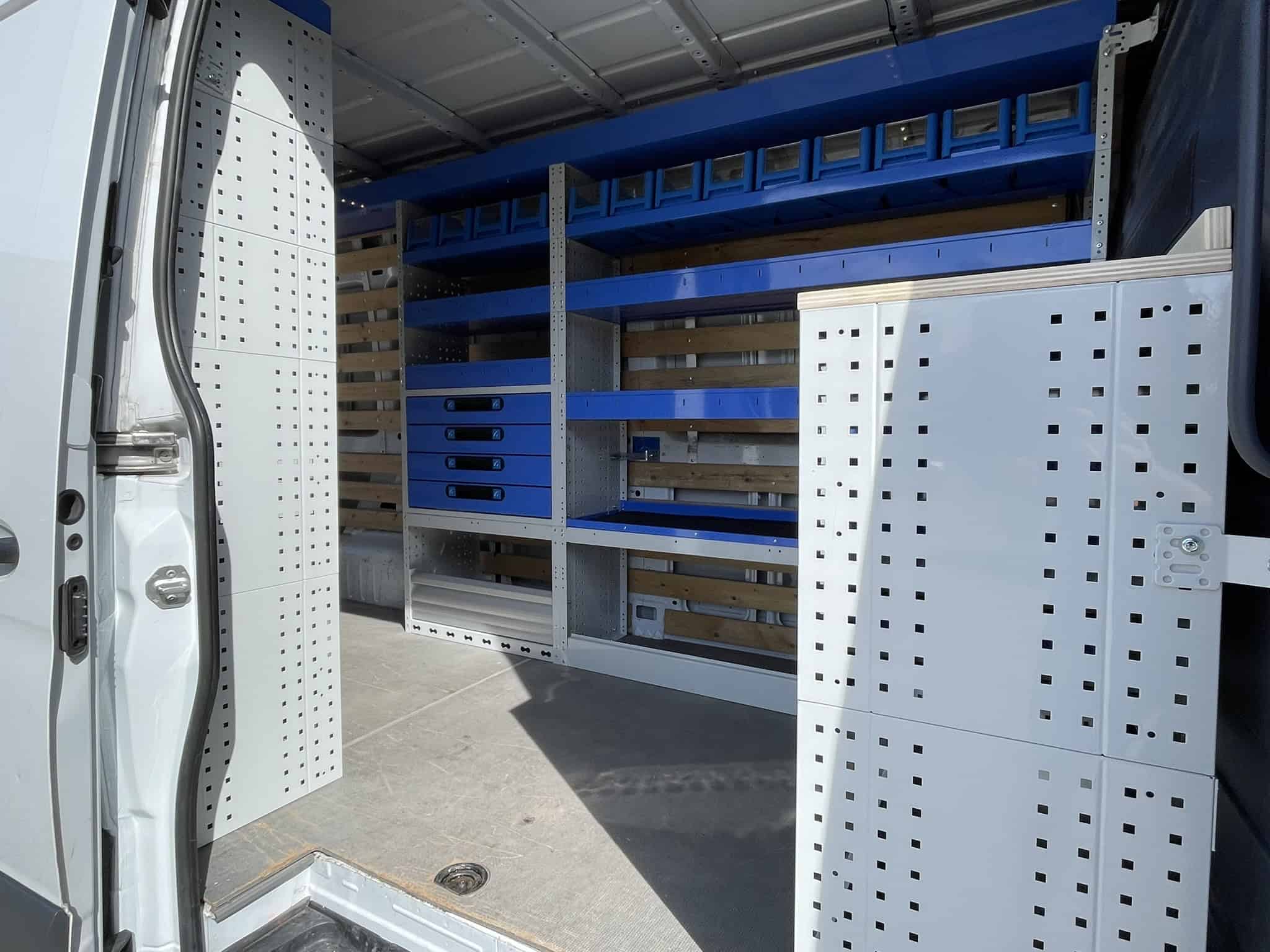 Bedrijfswagen met georganiseerde opbergkasten en rekken voor efficiënt werk en opslag.