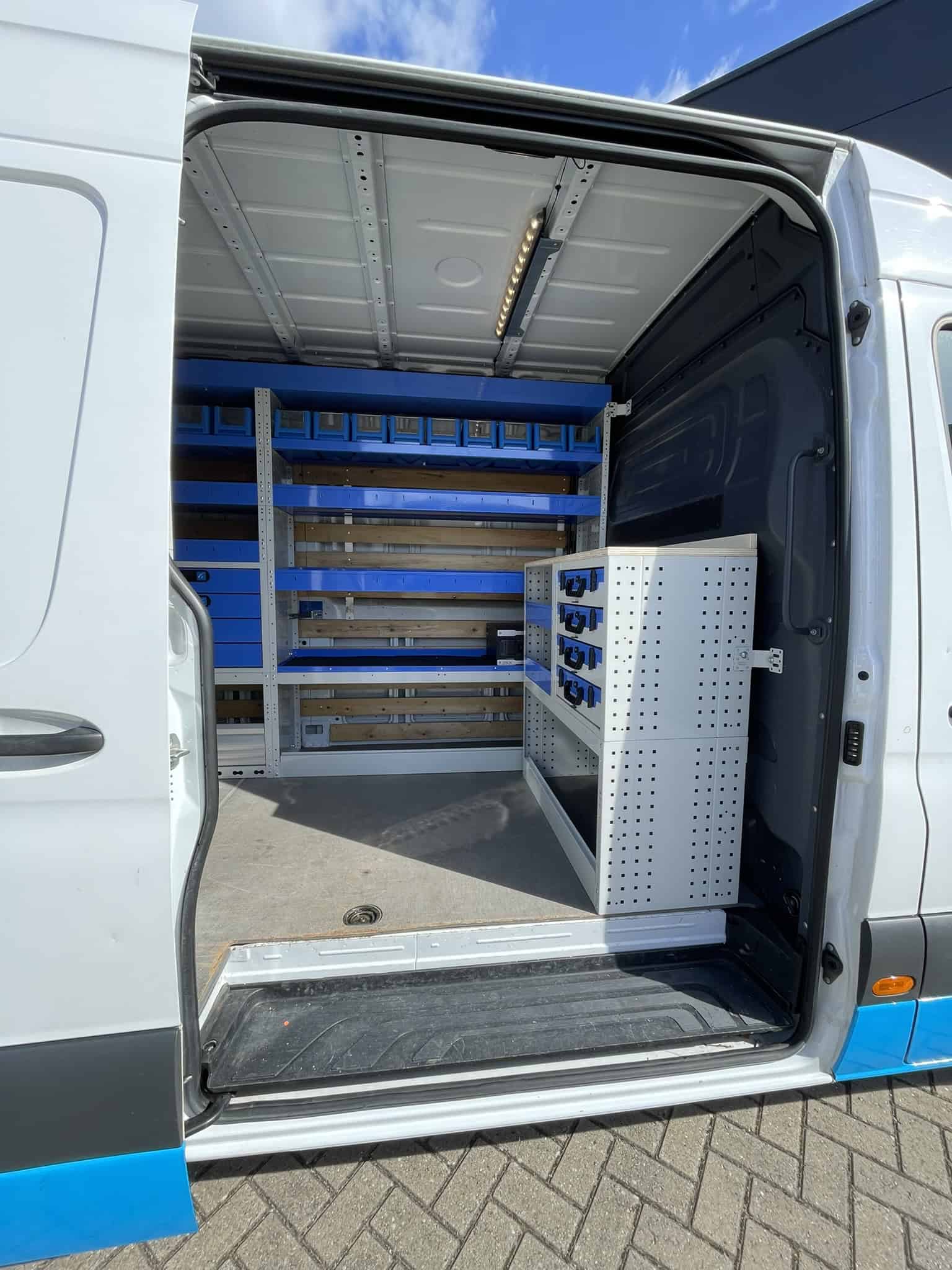 Interieur van een bedrijfswagen met op maat gemaakte opbergoplossingen en rekken voor efficiënte organisatie.