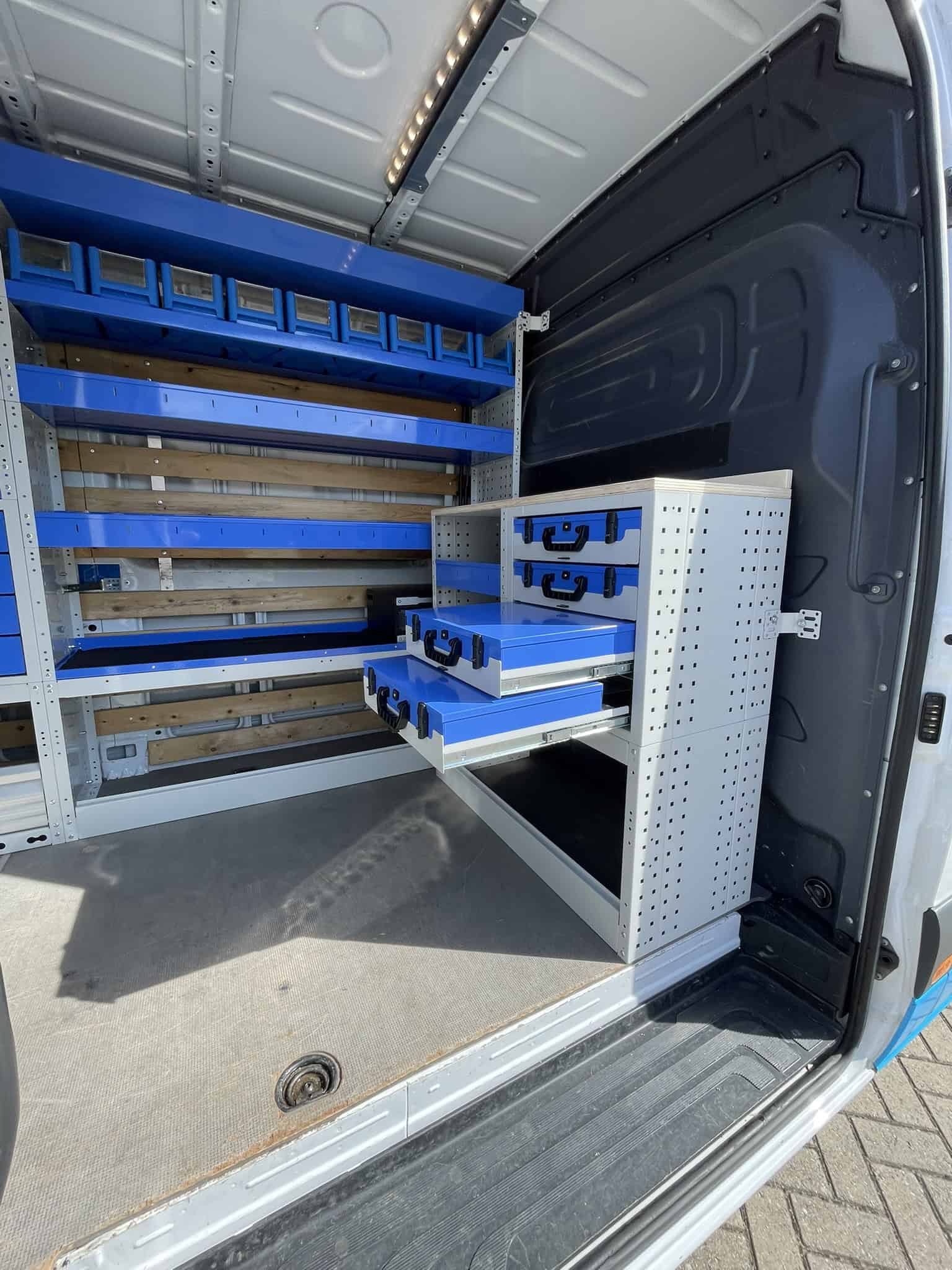 Georganiseerde bedrijfswagen met blauwe opbergkasten en lades voor efficiëntie en opslag.