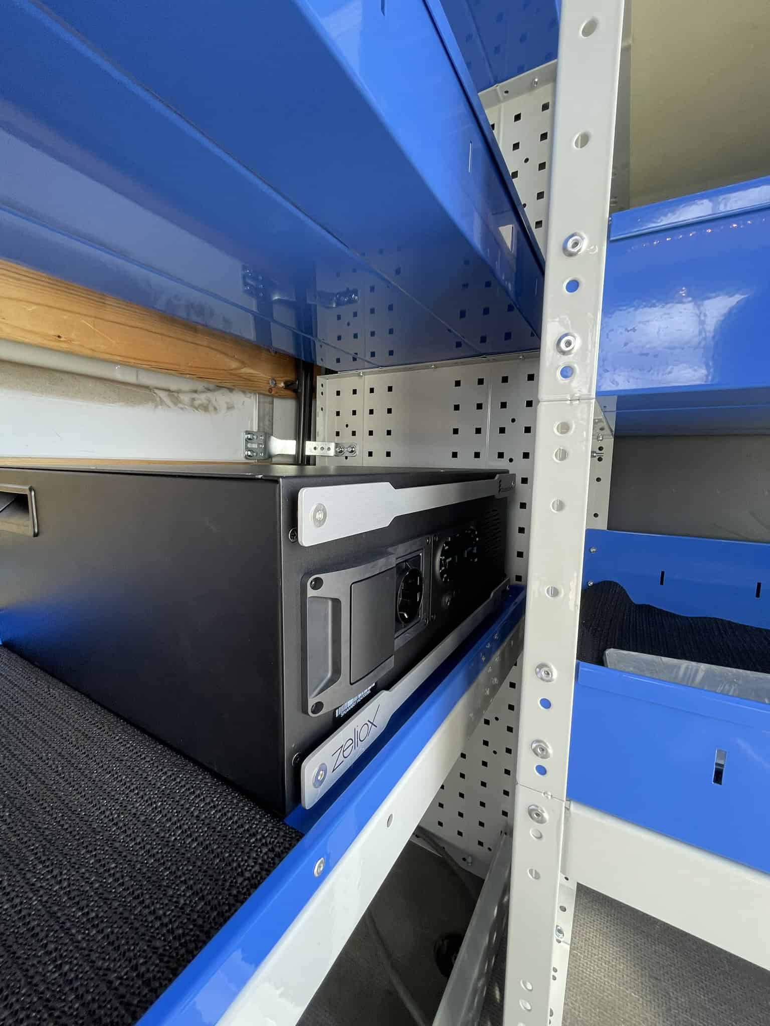 Binnenkant van een bedrijfswagen met professionele inrichting en ingebouwd laadstation voor elektrische voertuigen.