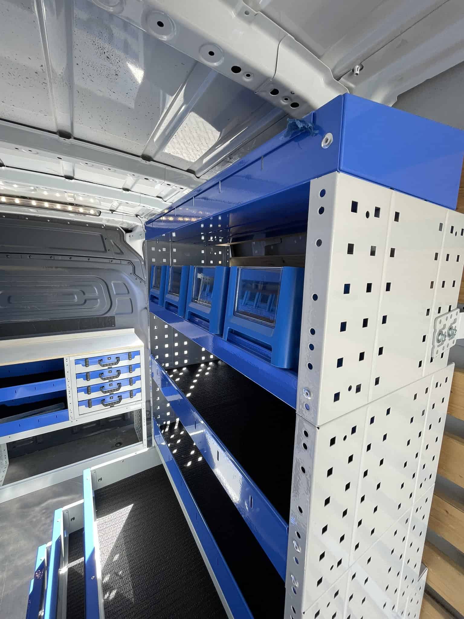 Binnenkant van een bedrijfswagen met georganiseerde opbergsystemen en gereedschapshouders voor efficiënt werk.