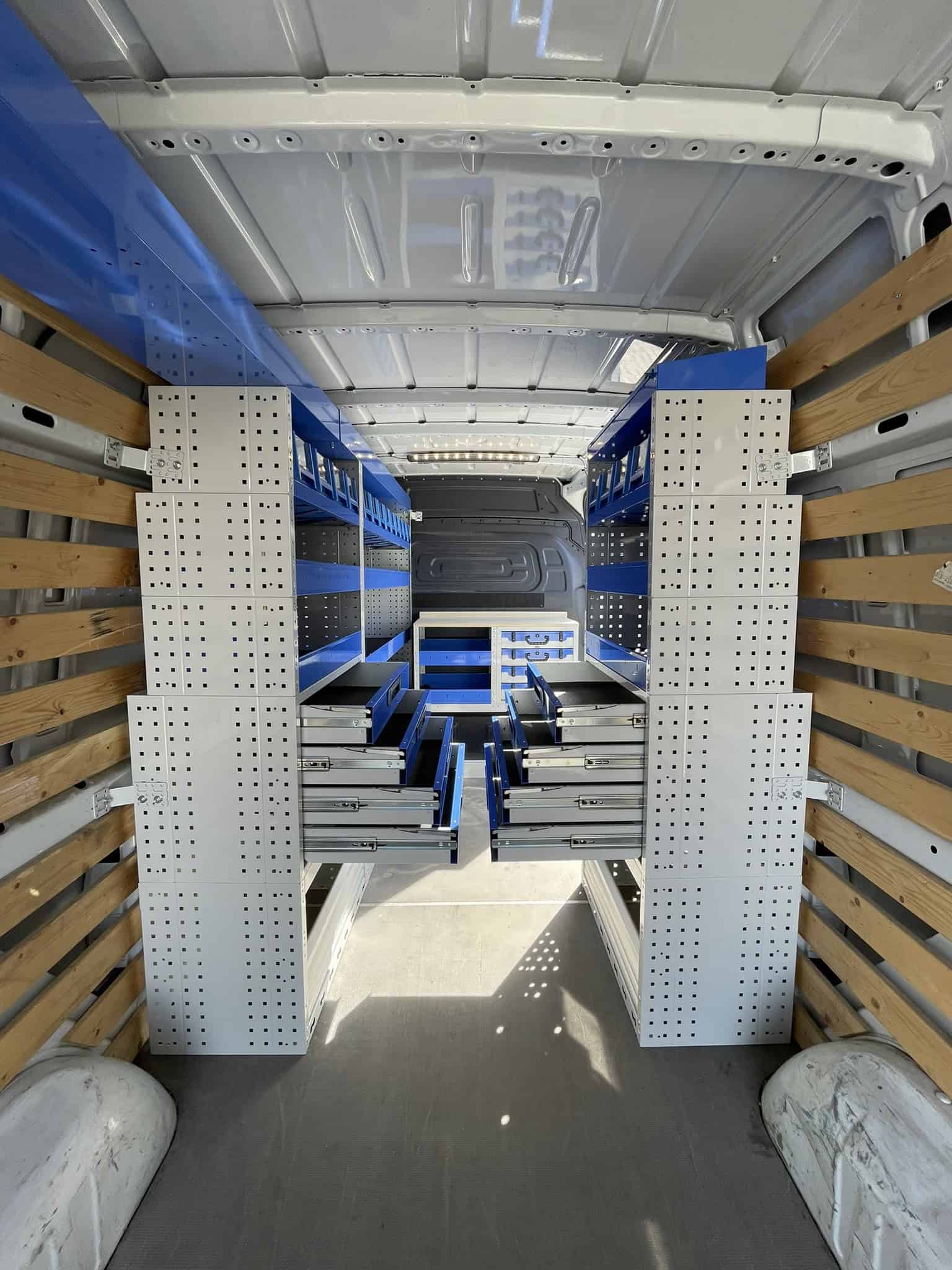 Interieur van een bedrijfswagen met opbergrekken en lades voor efficiënte opslag en organisatie.