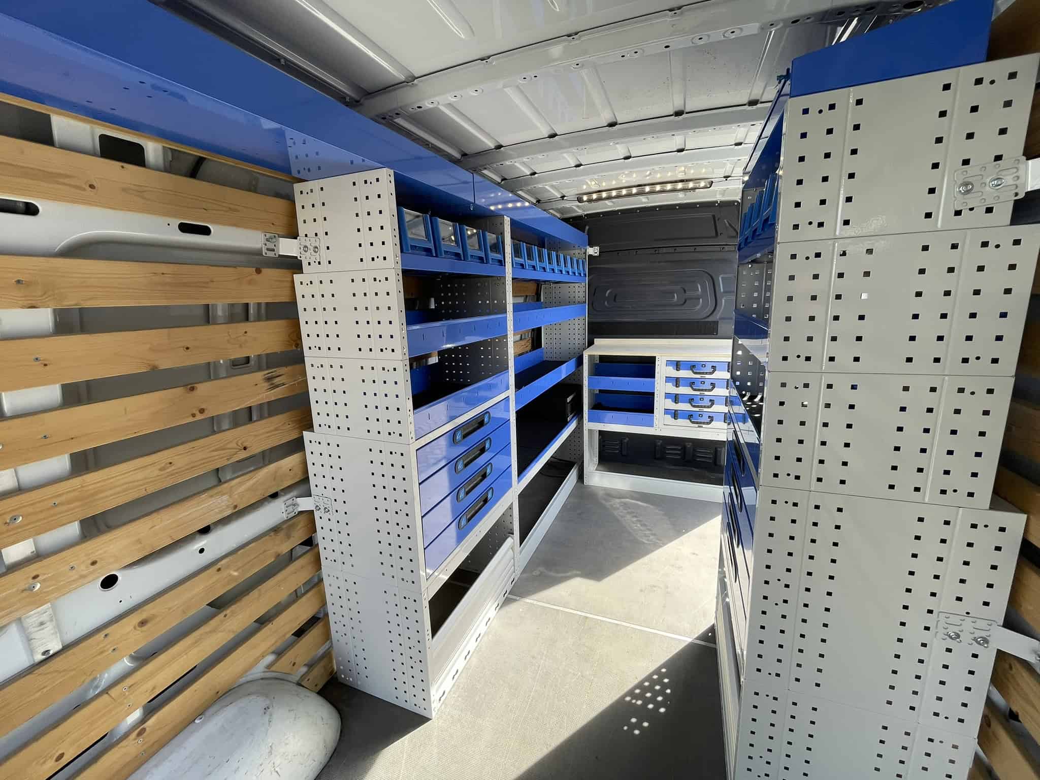 Binneninrichting van bedrijfswagen met op maat gemaakte opbergoplossingen en legborden voor efficiëntie en organisatie.