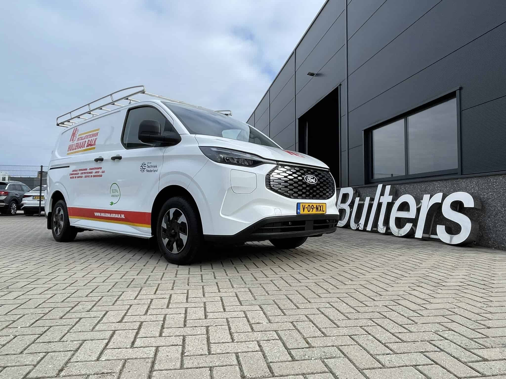 Moderne witte bedrijfswagen met bedrijfslogo geparkeerd voor Bulters, gespecialiseerd in bedrijfswageninrichting, op een heldere dag.
