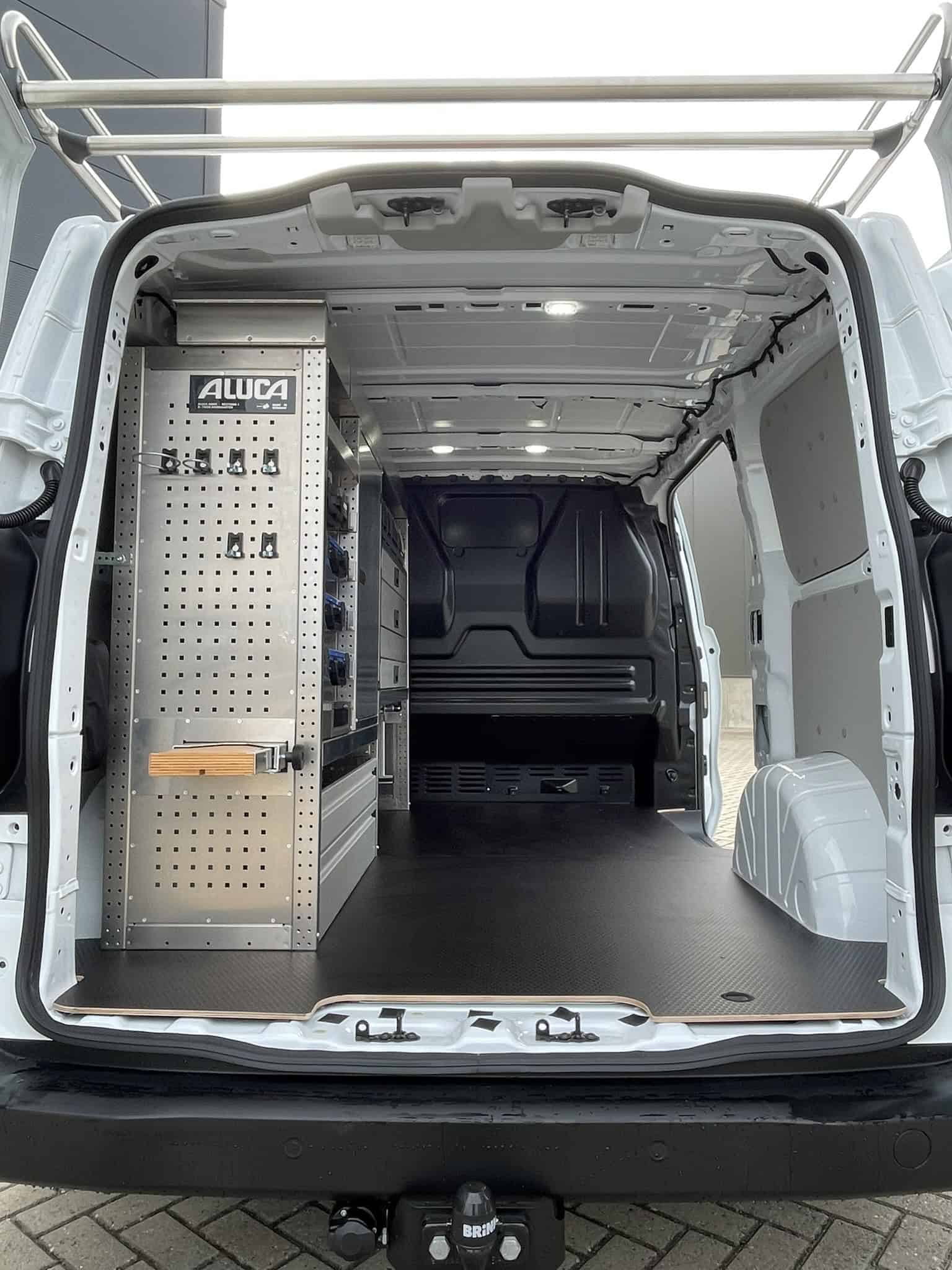 Interieur van een bedrijfswagen met georganiseerde opbergkasten en werkruimte, ideaal voor vakmensen en bedrijven.
