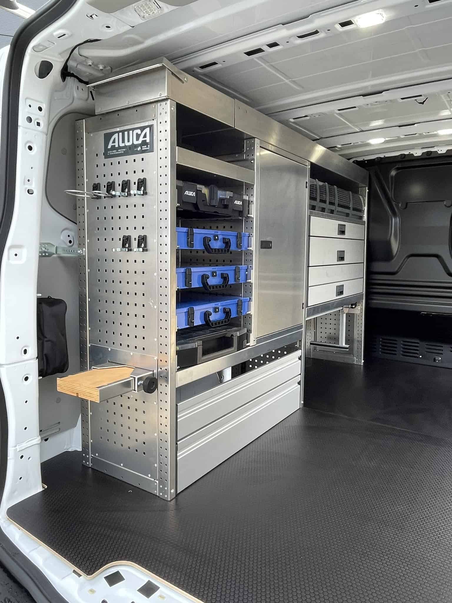 Georganiseerde bedrijfswageninrichting met metalen opbergkasten en lades voor efficiënt werk.