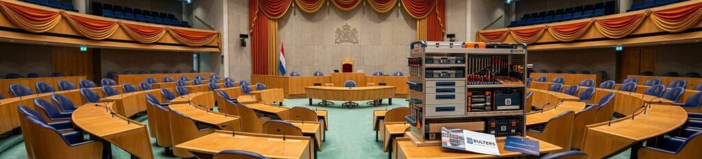 Vergaderzaal met ronde tafel en comfortabele stoelen, geschikt voor zakelijke bijeenkomsten en conferenties.