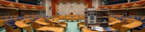 Vergaderzaal met ronde tafel en comfortabele stoelen, geschikt voor zakelijke bijeenkomsten en conferenties.